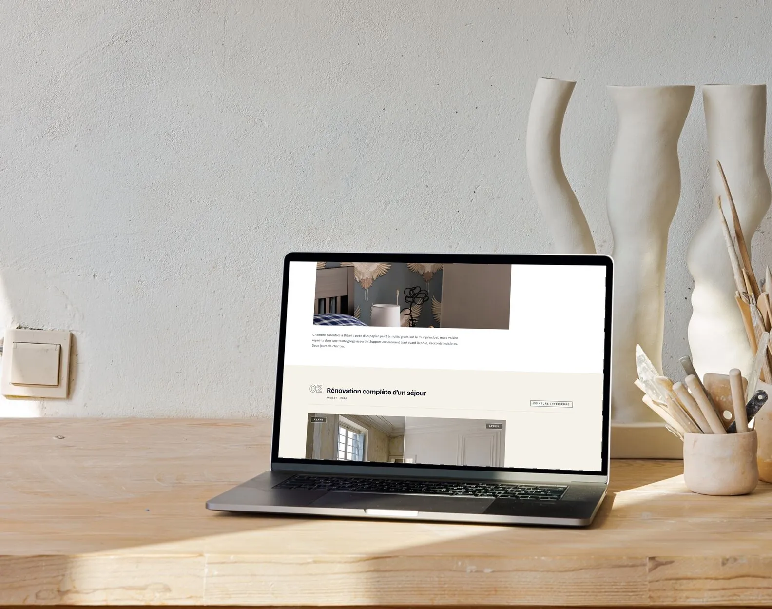 La galerie de réalisations d’un site que nous avons fait, pleine de photos de chantier, ouverte sur un ordinateur posé sur un plan de travail en bois.