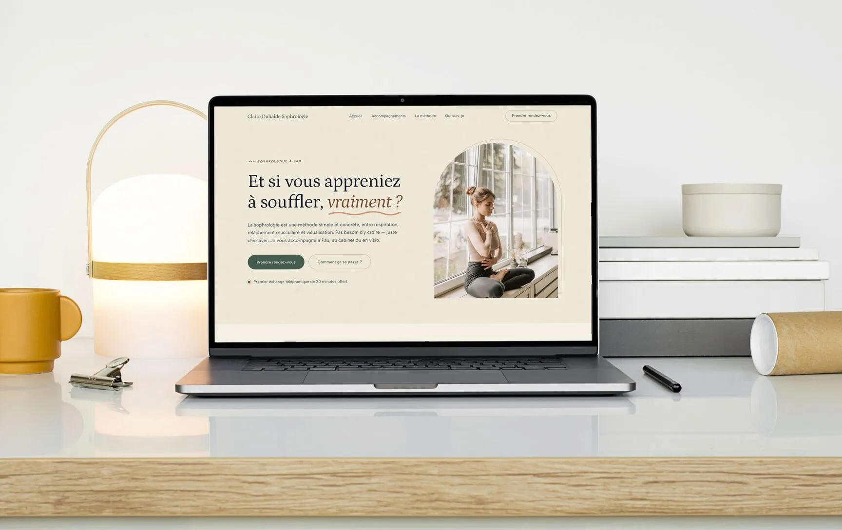 Le site d’une sophrologue affiché sur un ordinateur portable, sur un plan de bois clair