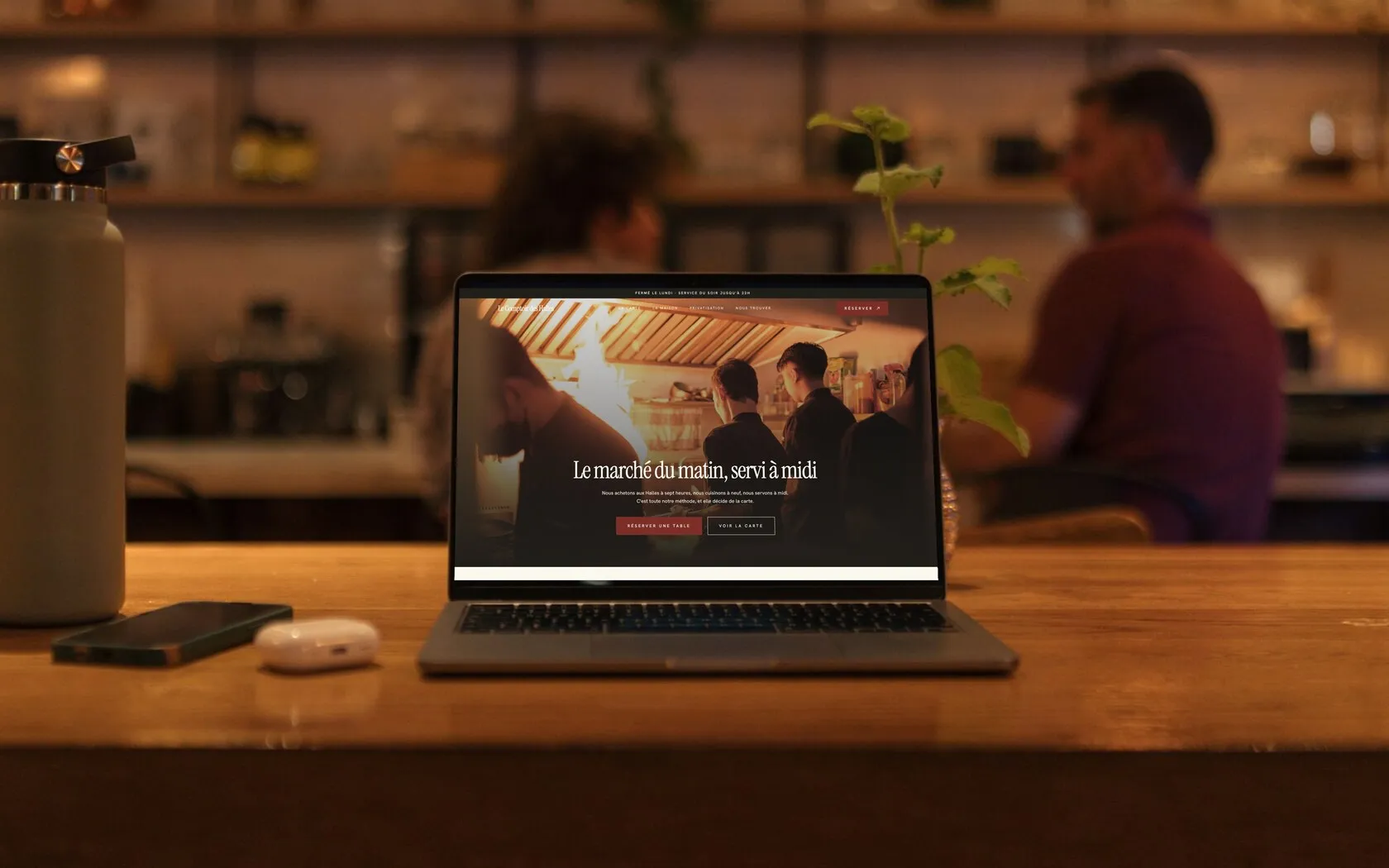 Le site d’un bistrot affiché sur un ordinateur portable, posé sur le comptoir de la salle