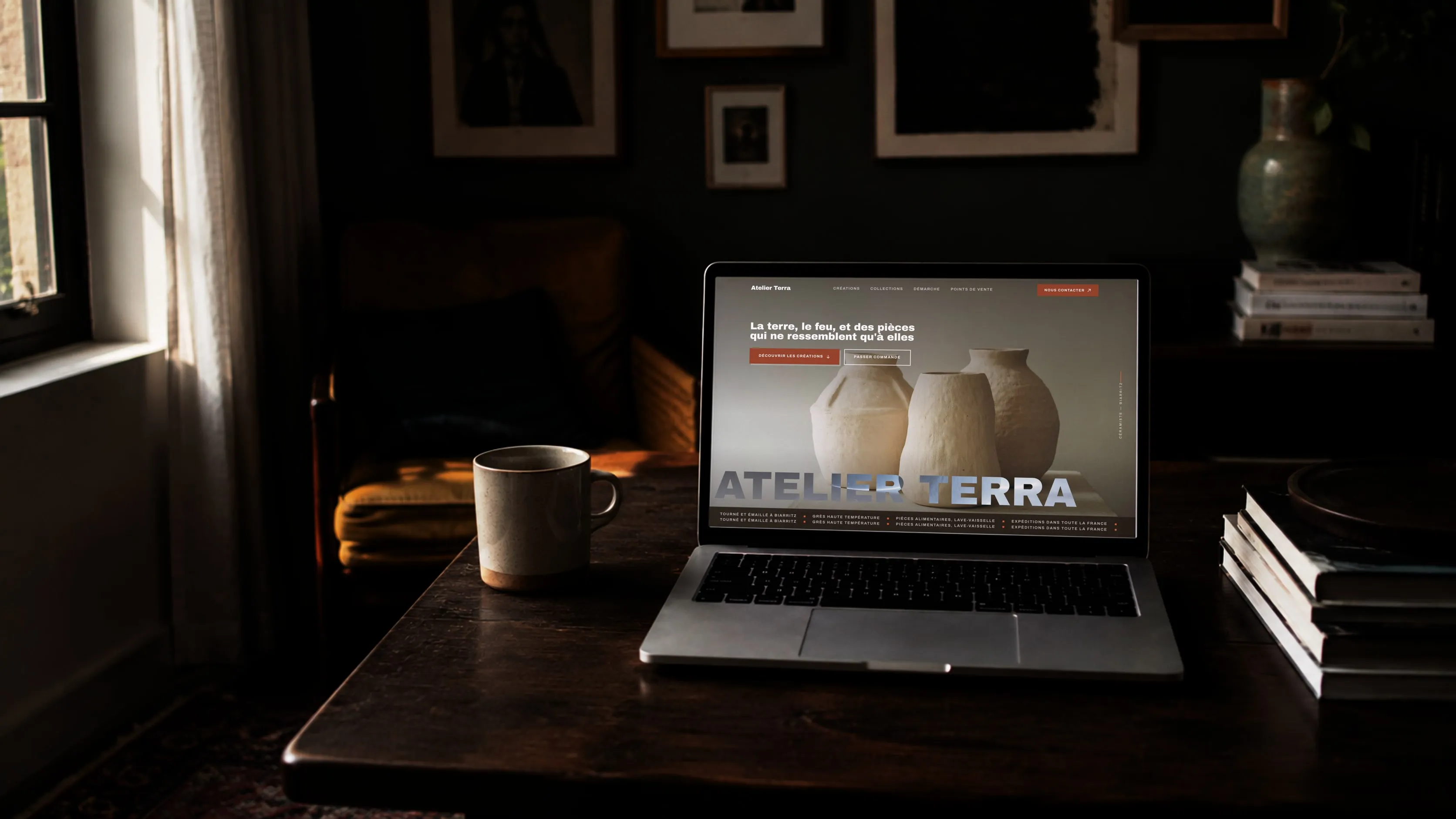Le site d’une céramiste affiché sur un ordinateur portable, sur une table sombre près d’une fenêtre